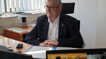 Wirtschaftsstaatssekretär Dr. Jürgen Ude vor dem Monitor der Videokonferenz zur digitalen ITB 2022
