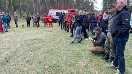 Eine Gruppe von Menschen befindet sich in einem Wald bei Wittenberg, wo der Ernstfall zur Bekämpfung der Afrikanischen Schweinepest geprobt wird.