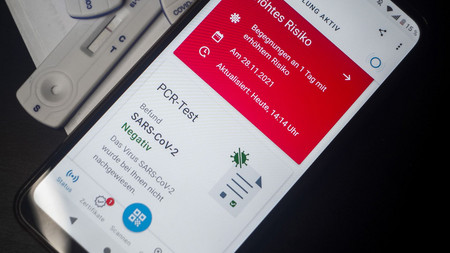 Smartphone zeigt digital das Ergebnis eines PCR-Test auf das Corona-Virus