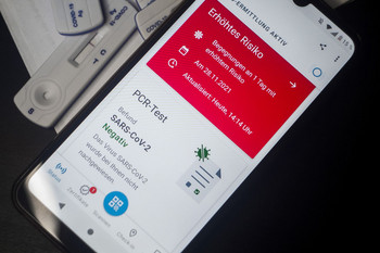 Smartphone zeigt digital das Ergebnis eines PCR-Test auf das Corona-Virus