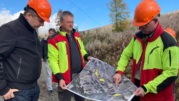 Minister Sven Schulze lässt sich anhand eines Lageplans des Nationalparks Harz die Totholzberäumung bei Schierke erläutern