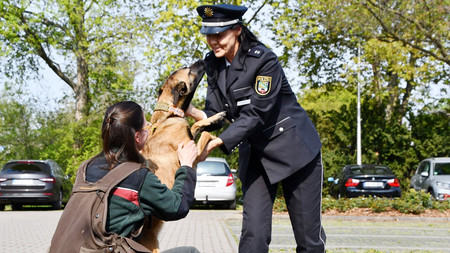 Kadaversuchhündin Lili mit zwei Frauen in Uniform